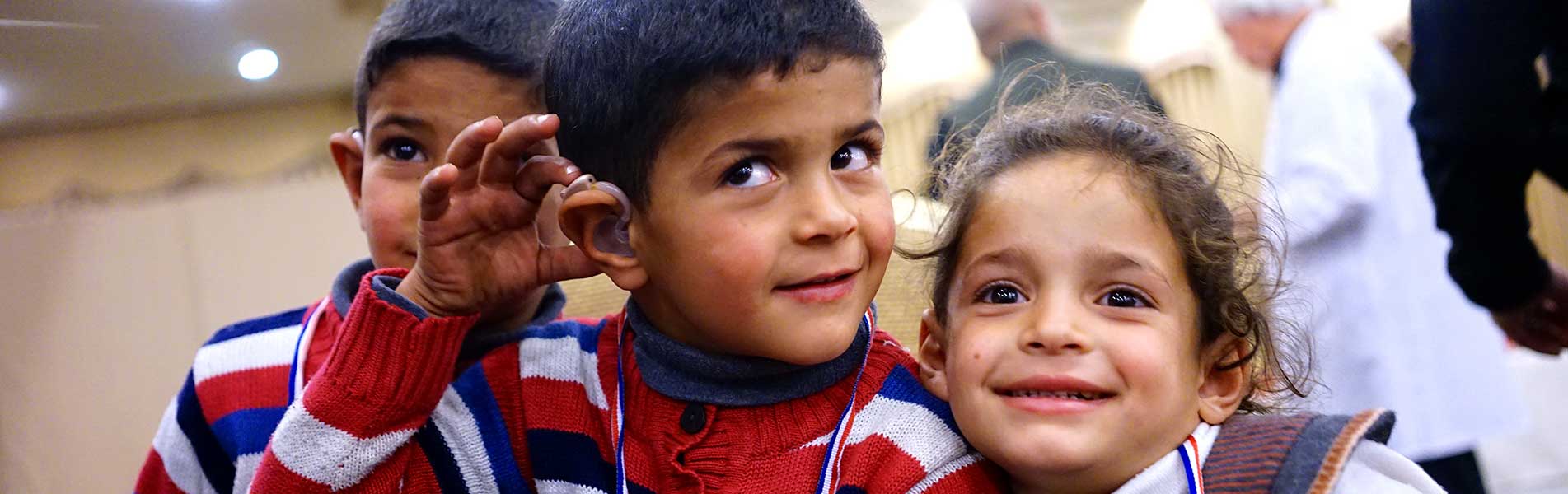 Three kids excited that one boy has hearing aids now