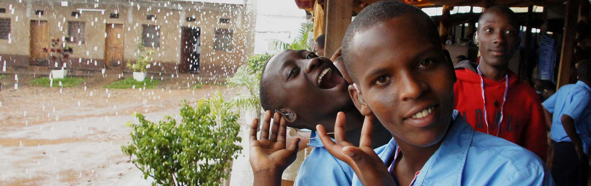 Young boy with hearing aid in Rwanda listening to the rain