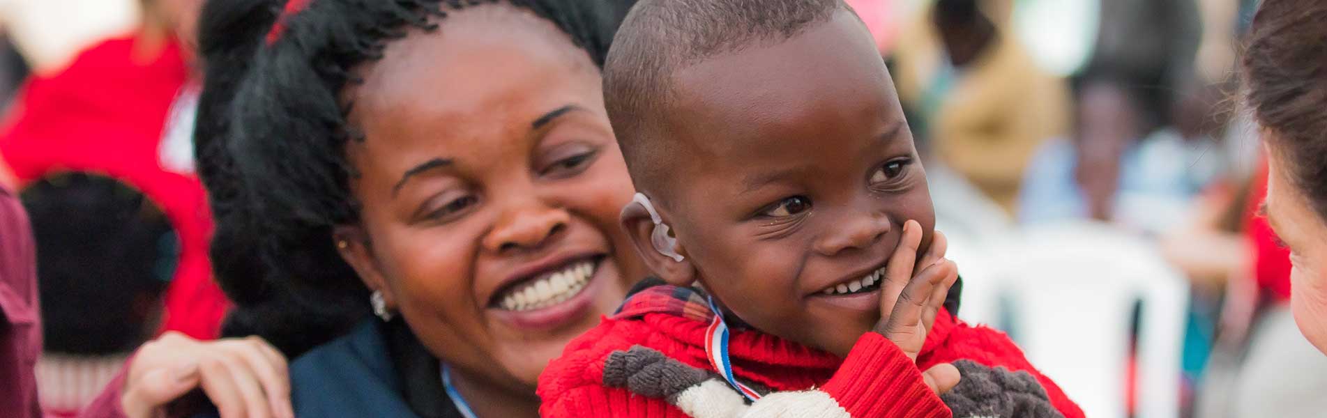 happy little kid with a hearing aid