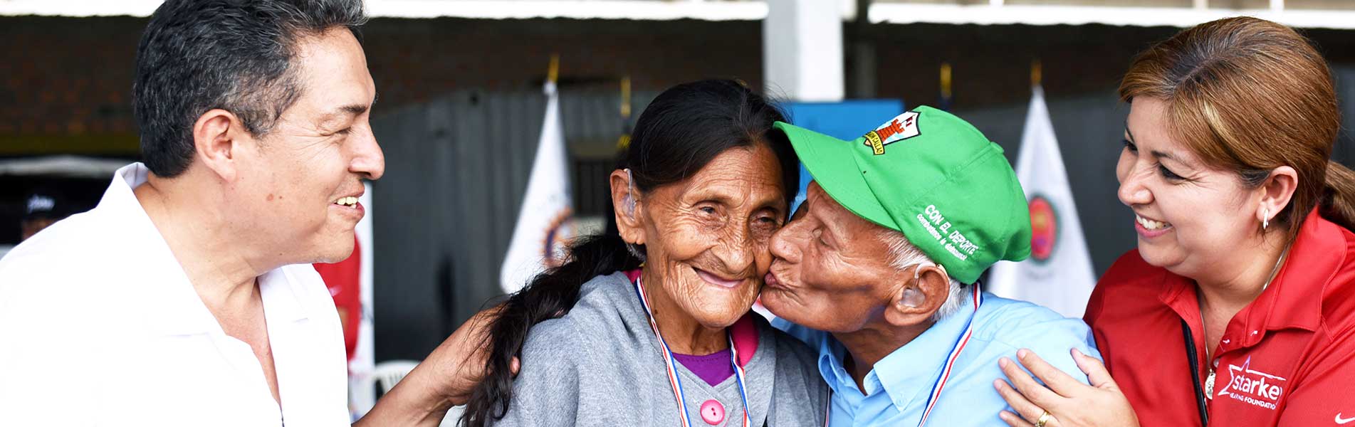 older couple kissing in Peru, being so happy to have a hearing aid