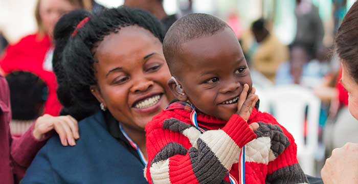 happy little kid with a hearing aid