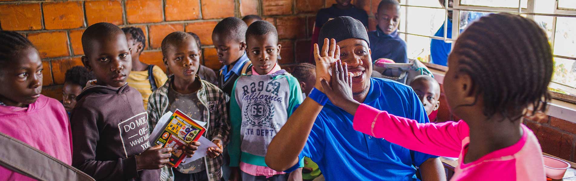 Starkey staff hi-fiving a young child with a new hearing aid