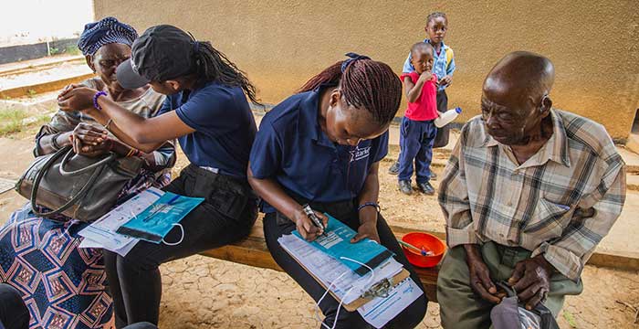 Starkey staff filling out info with people n Africa