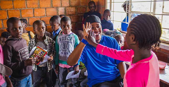 Starkey staff hi-fiving a young child with a new hearing aid