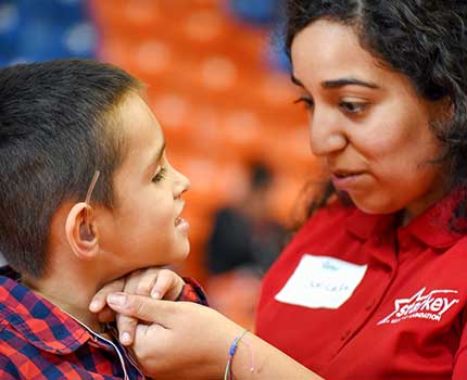 Starkey staff fitting new hearing aids on a small boy